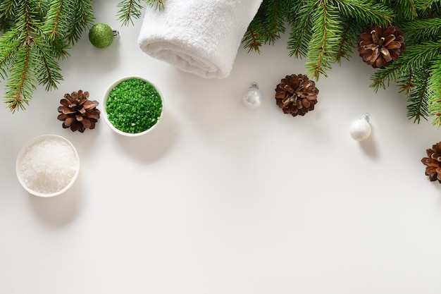 Christmas Spa wellness concept with cosmetic aroma oil pine cones on white background