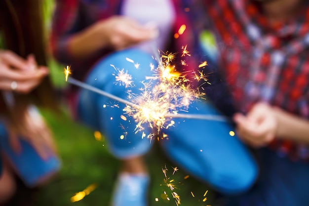 Christmas sparklers Group of friends enjoying party People are are holding christmas sparklers