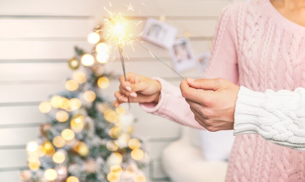 Christmas sparklers in the hands of a man and a woman. Holiday. Selective focus. People.