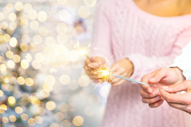 Foto stelle filanti di natale nelle mani di un uomo e una donna. vacanza. messa a fuoco selettiva.