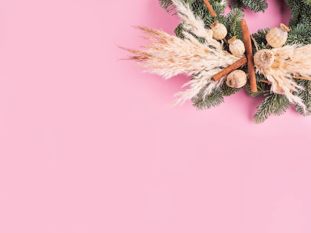 Christmas spruce wreath with dry decor on pink