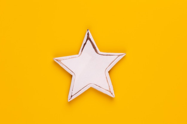 Christmas star decor on yellow colored background.