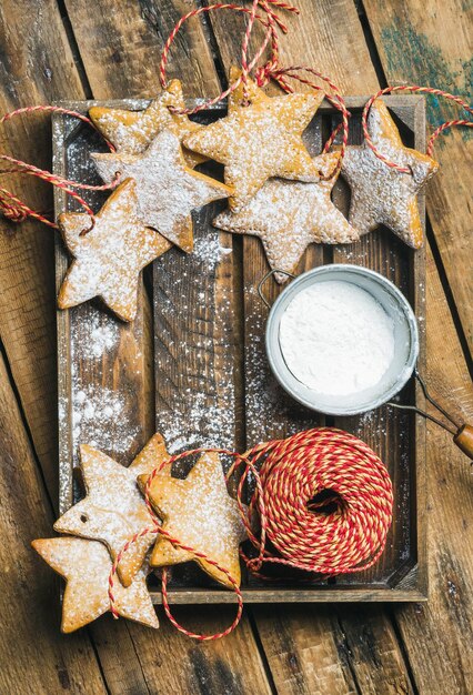 砂糖粉と装飾ロープが付いているクリスマスの星形のクッキー