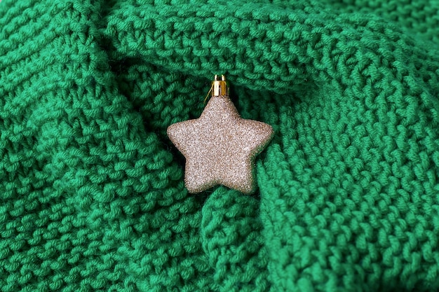 ニットセーターの上のクリスマスの星のおもちゃ