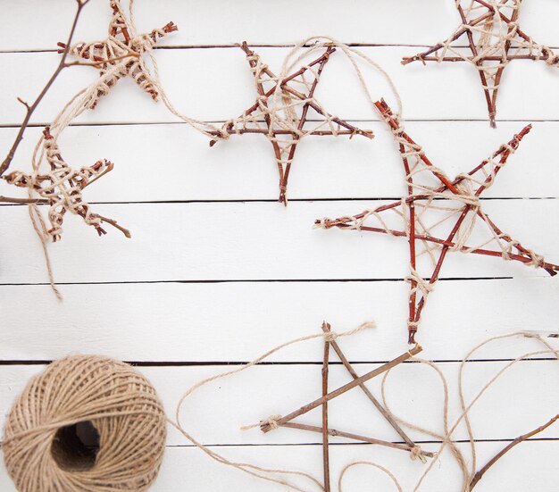 Photo christmas stars made from twigs and jute rope, frame, copy space, top view. make stars with your own hands.