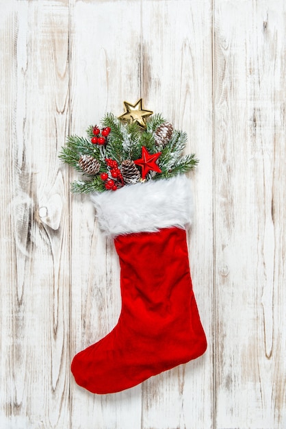 写真 木製の背景に松の枝とクリスマスの靴下の装飾