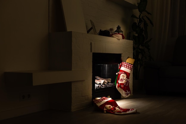 Christmas stocking hanging from a mantel or fireplace, decorated for Christmas with fire glowing.