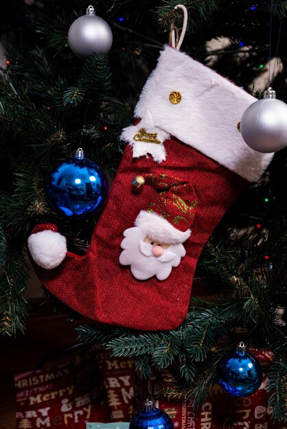 Christmas stocking Red sock with snowflakes for Santa's gifts hanging on the Christmas tree Winter holidays