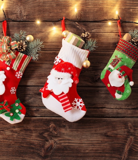 Christmas stocking with gifts hanging on dark old wooden background