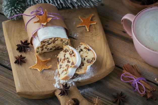 Christmas Stollen sliced on a wooden board with cinnamon stick and anise stars. Stollen for Christmas.Seasonal holidays concept.