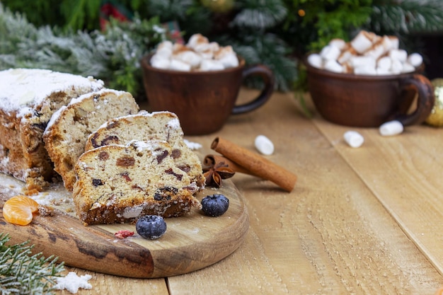 Photo christmas stollen with a mixture of dried fruits nuts and powdered sugar on a board