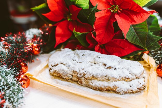 Photo christmas stollen with tinsel and flower christmas star or poinsettia