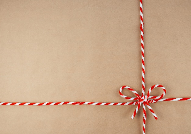 Christmas string or twine tied in a bow on kraft paper backdrop