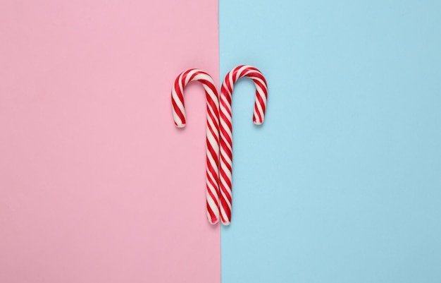 Christmas striped candy canes on a blue pink background