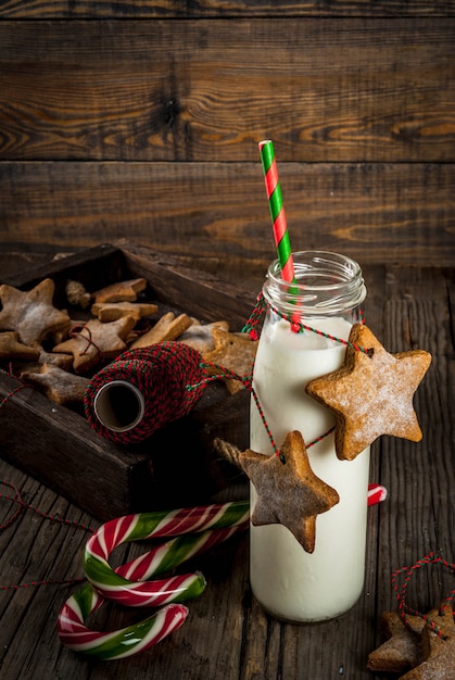 Dolci e dolcetti di natale, bottiglie con latte per babbo natale con biscotti di panpepato stelle con corda di decorazione, legno vecchio,