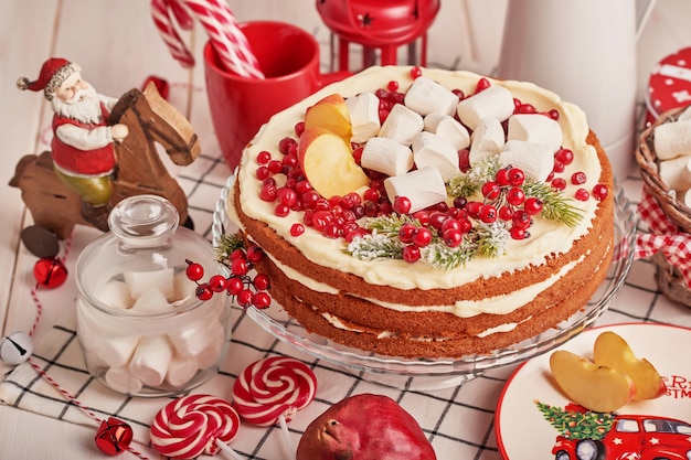 Decorazione della tavola di natale, torta di frutta festiva con dolci sul tavolo