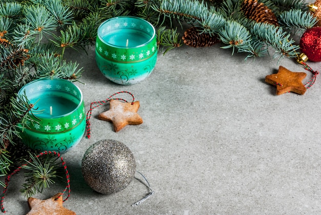 Christmas table,  for greeting card. Christmas decoration, candles, fir tree and gingerbread cookies on grey stone table. .