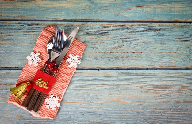 Decorazione della regolazione di posto della tavola di natale con il cucchiaio e la lama della forchetta sul tovagliolo