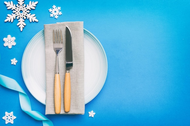 Christmas table place setting with christmas decor and plates kine fork and spoon Christmas holiday background Top view with copy space