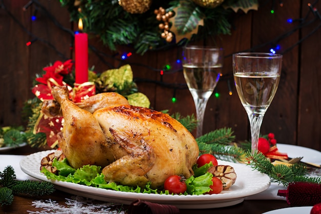 Christmas table served with a turkey, decorated with bright tinsel and candles