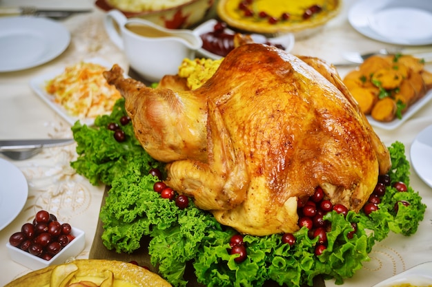 Christmas table served with turkey, decorated with kale and cranberry. Holiday New Year concept.