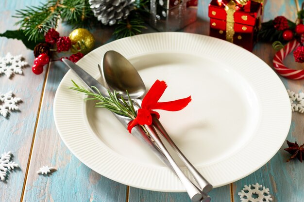 Christmas table setting Festive plate and cutlery with decor on festive table