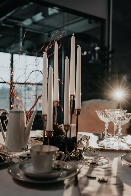 Christmas table setting with cups candles glasses teatime