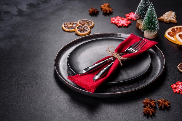 Christmas table setting with empty black ceramic plate fir tree and black accessories