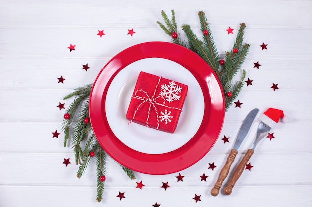 Christmas table setting with fir branch and gift box on white background