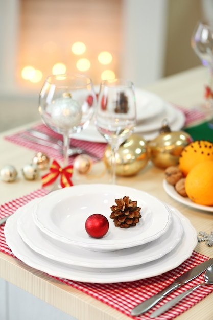 Christmas table setting with holiday decorations on fireplace