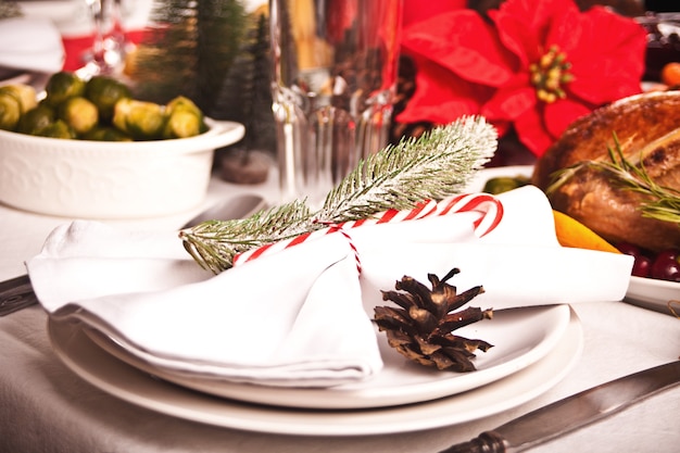 Christmas table setting with holiday decorations. New Year celebration.