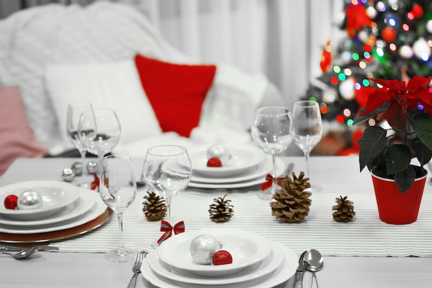 Christmas table setting with holiday decorations surface