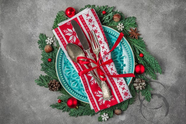 콘크리트 테이블에 접시, 칼 붙이, 전나무 나뭇가지, 크리스마스 장식이 있는 크리스마스 테이블 설정. 평면도. 크리스마스 배경