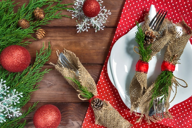 Christmas table setting with plate, silverware and decorations