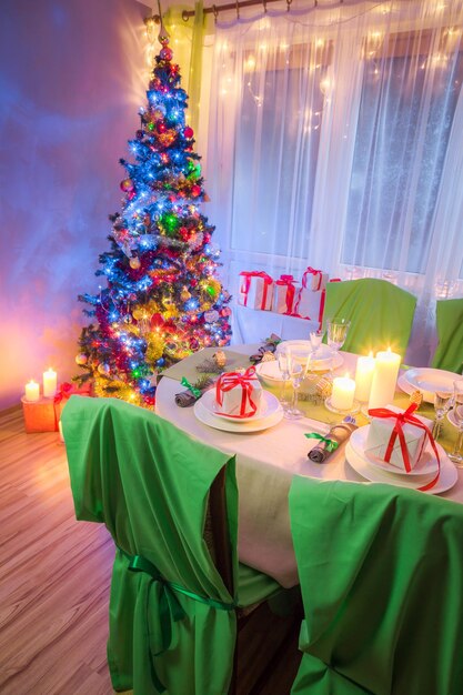 Christmas table setting with present and tree in frosty evening