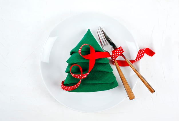 写真 白いプレートと緑のクリスマスツリー、トップビューナプキンホワイトクリスマステーブル設定