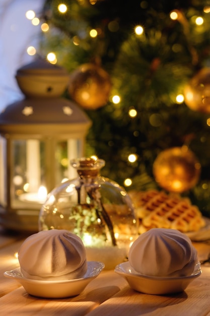 Christmas table with a Christmas tree marshmallows tangerines and garlands