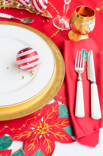 Christmas table with white and golden plate, knife and fork