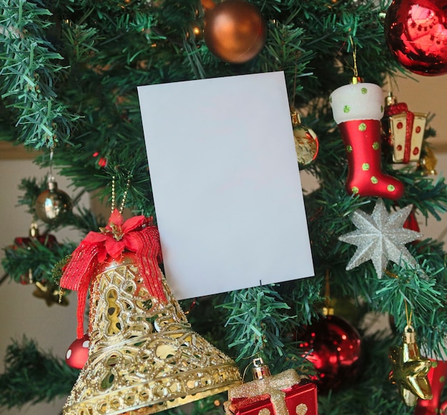 Фото Рождественский фон шаблона с пустой белой поздравительной открыткой для пригласительного письма или входящего электронного маркетинга. в окружении праздничных украшений.