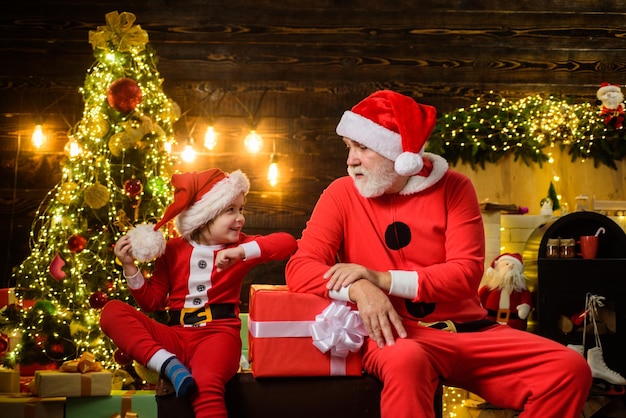 Christmas time happy holidays christmas boy in santa costume with santa claus santa claus man and