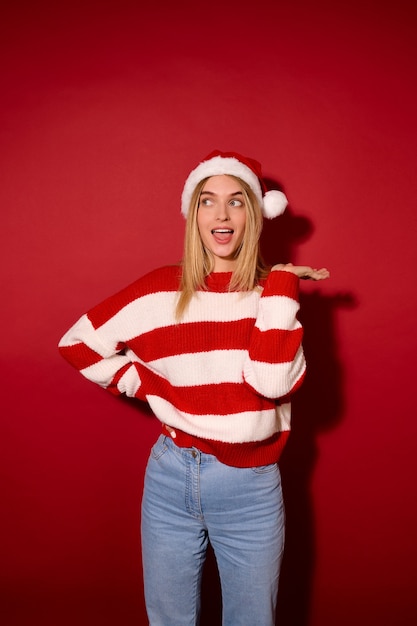 Christmas time. Pretty young girl in a santa hat and a striped sweater