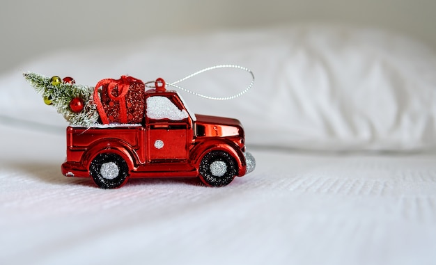 Christmas toy car on a white bed. the concept of happy christmas, new year, holiday, winter, greetings.