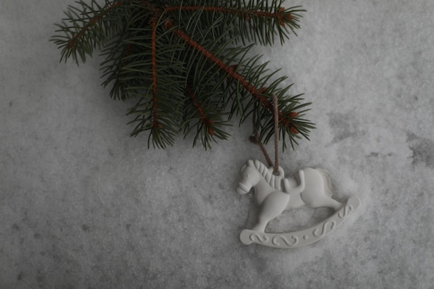 Christmas toy horse hanging on a green branches in the snow in winter Christmas tree toy horse gift New Year decor