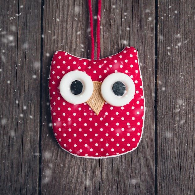 Christmas toy made of cloth owl on a wooden background