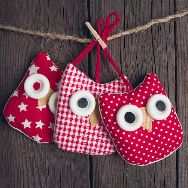 Christmas toy made of cloth owl on a wooden background