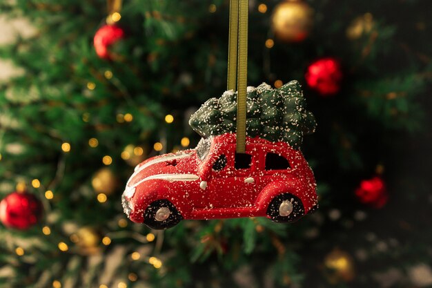 Photo christmas toy red car on new year tree. christmas composition.