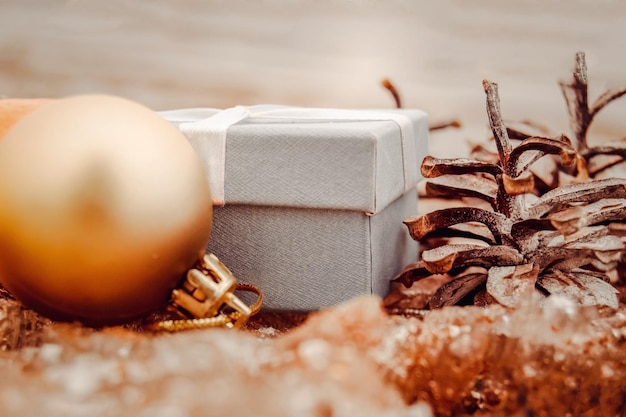 Christmas toys golden balls and a gift box on the beach blurred\
sea in the background new year or christmas card