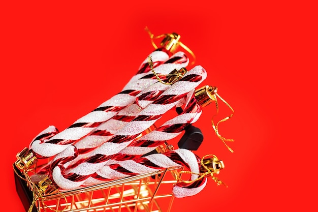 Christmas toys in a grocery cart on a red background. Christmas and New Year composition in red white.