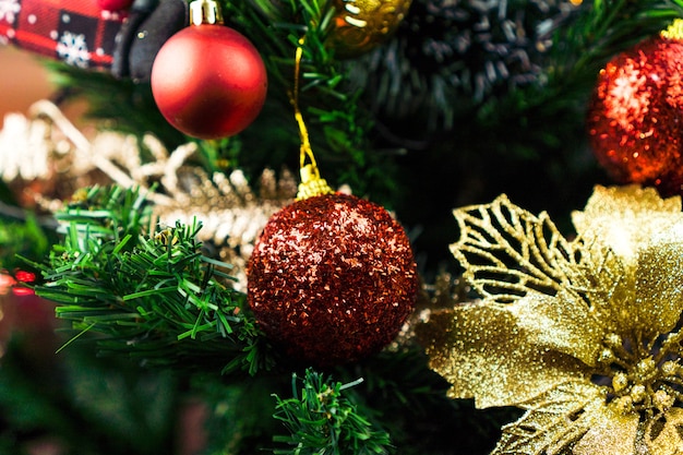 Christmas tree assembled with ornaments. Red, silver and gold balls, gift boxes, lights, Santa Claus and others. Selective focus.