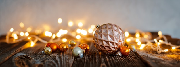 Игрушка шарика рождественской елки кладет деревянный стол против светов праздника bokeh.